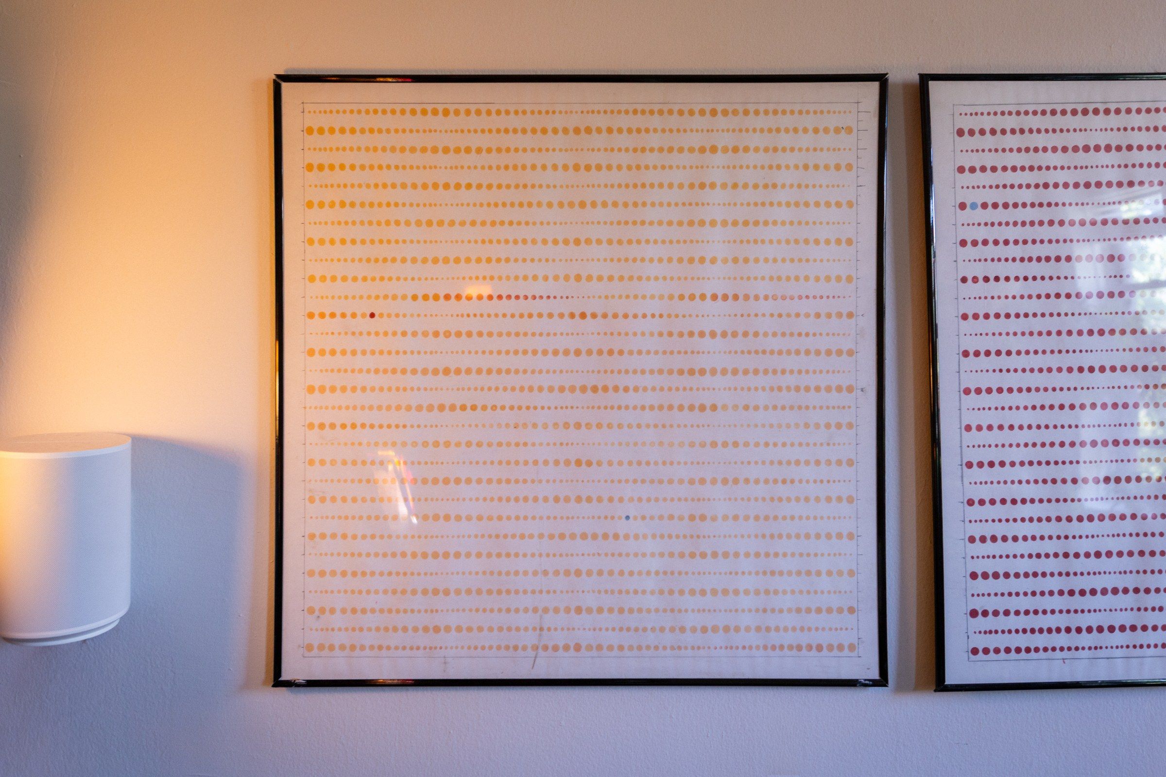 A single dot drawing up close: a faint grid of marker dots across pale translucent paper.