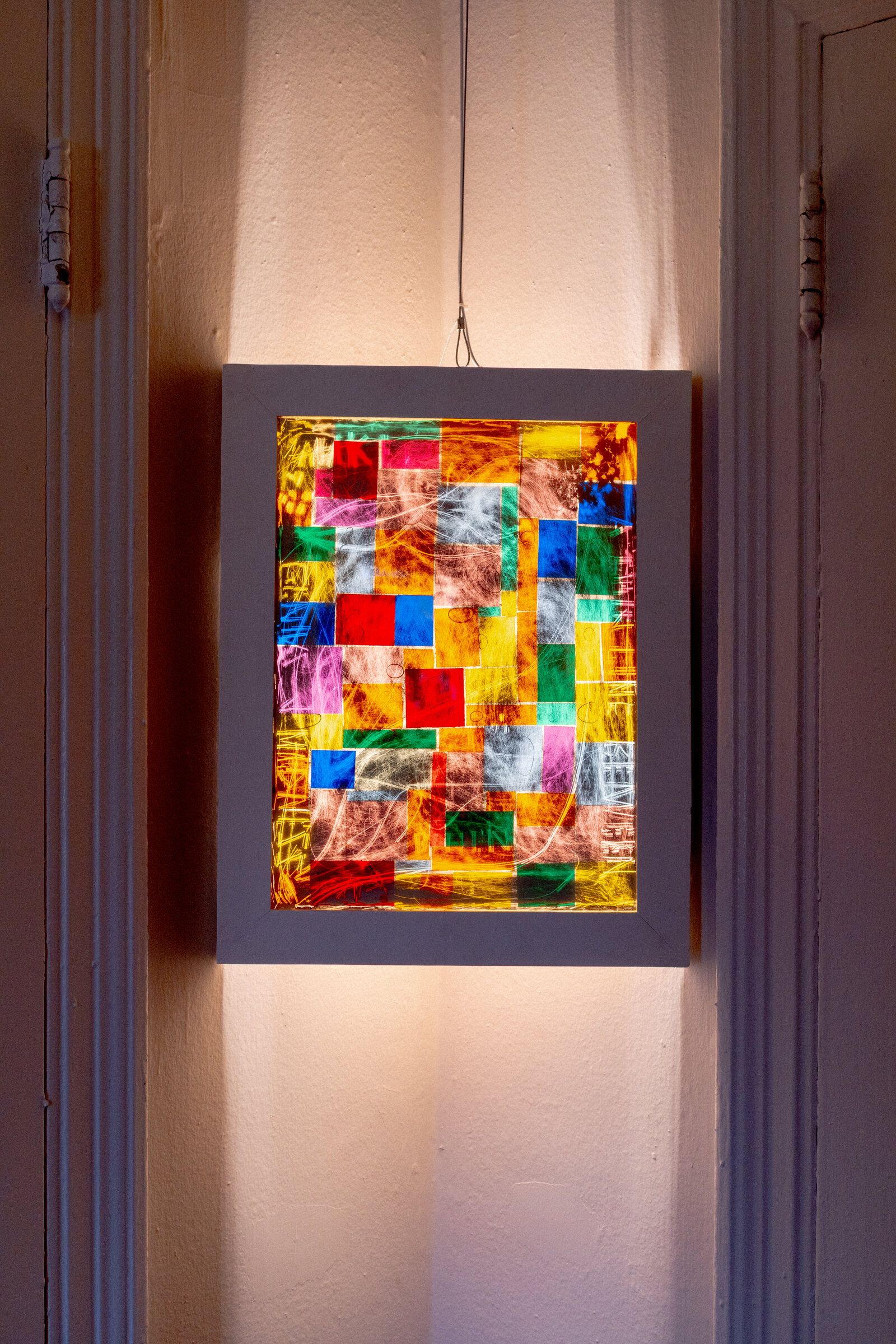Closer view of genius madness mirror: colored squares stacked in a loose grid, white scratched marks moving across the surface, the frame visible around all four edges