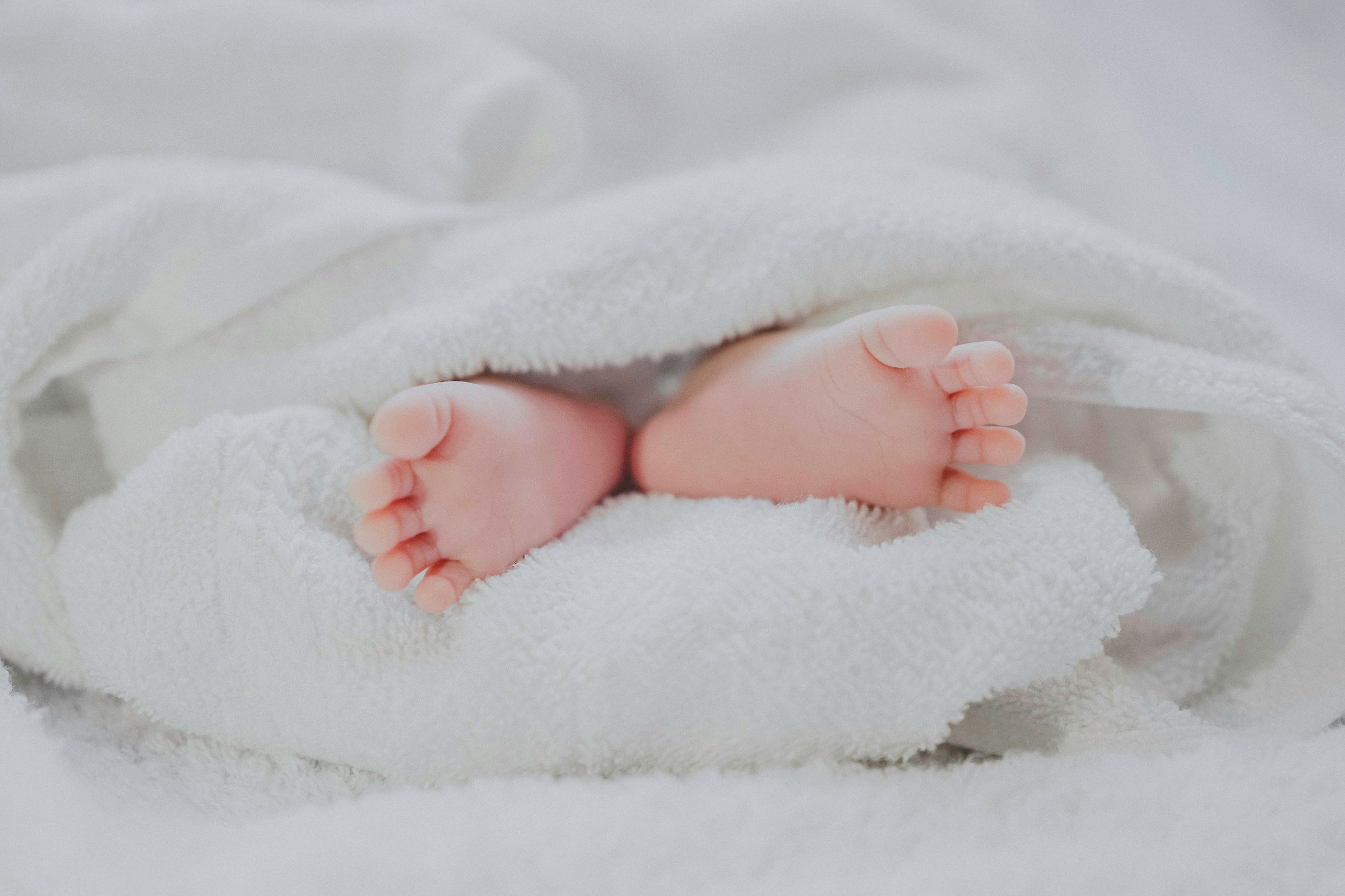 Babyfüße in einer weißen Decke