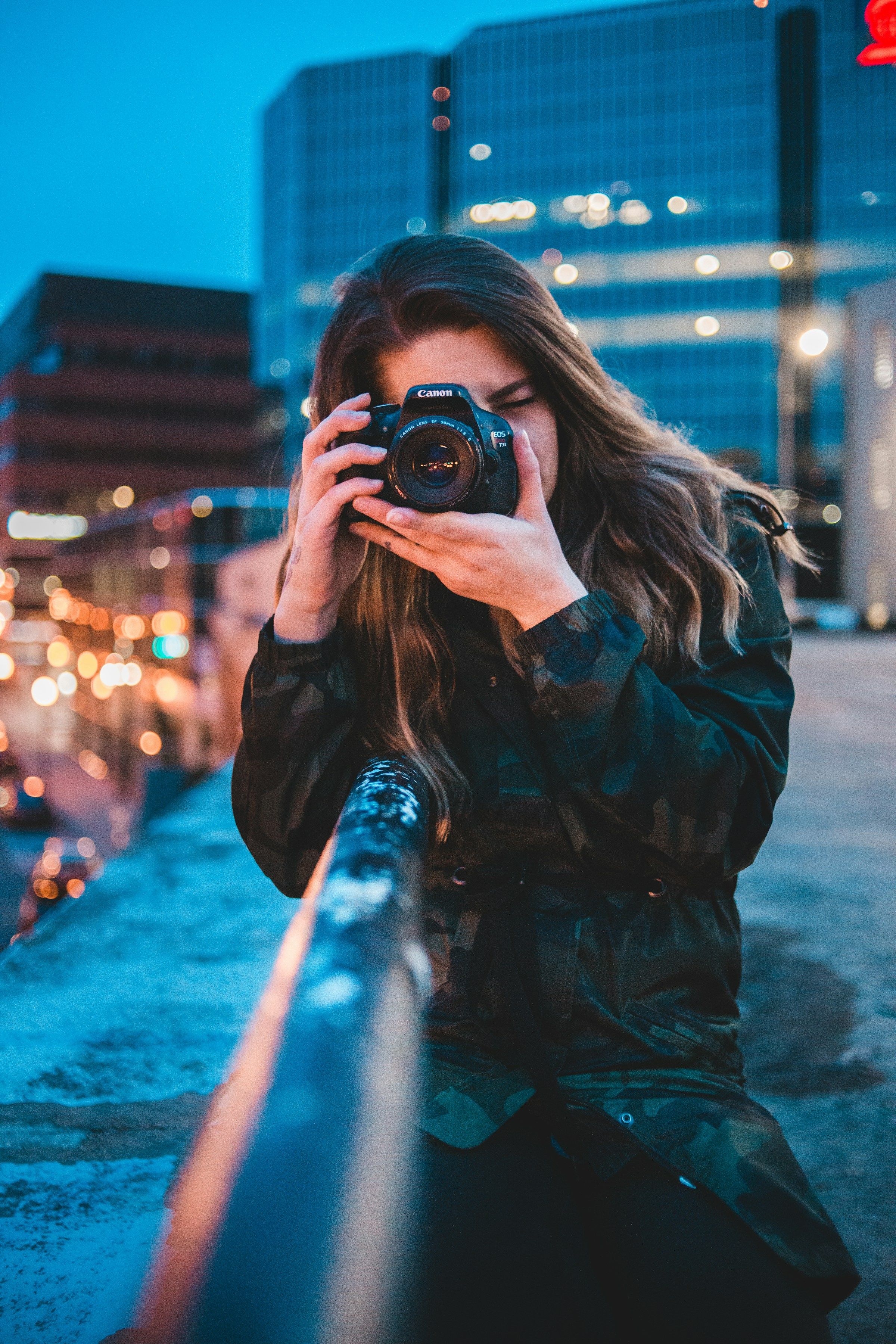 Fotografin mit Kamera in der Stadt am Abend