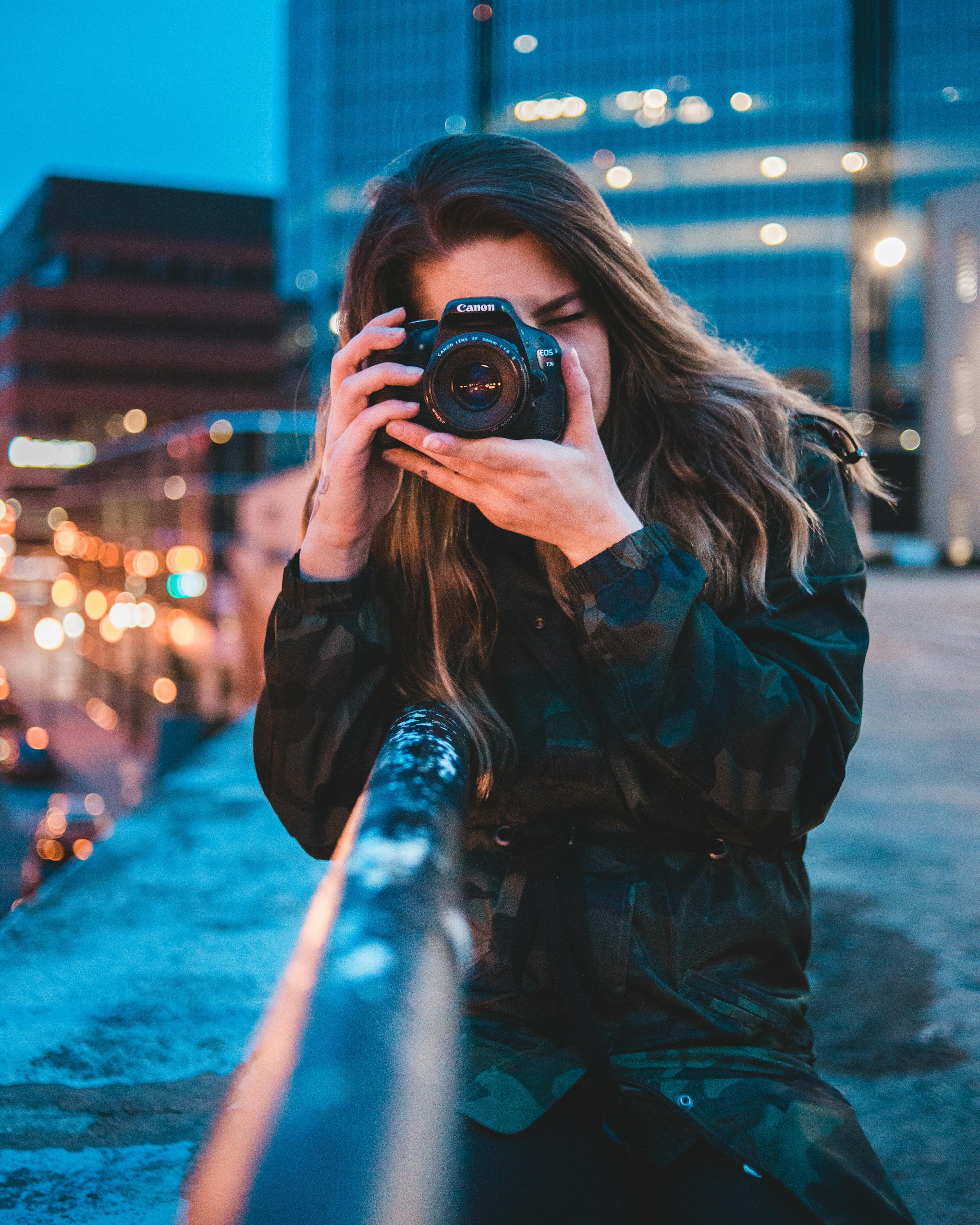 Fotografin mit Kamera in der Stadt am Abend