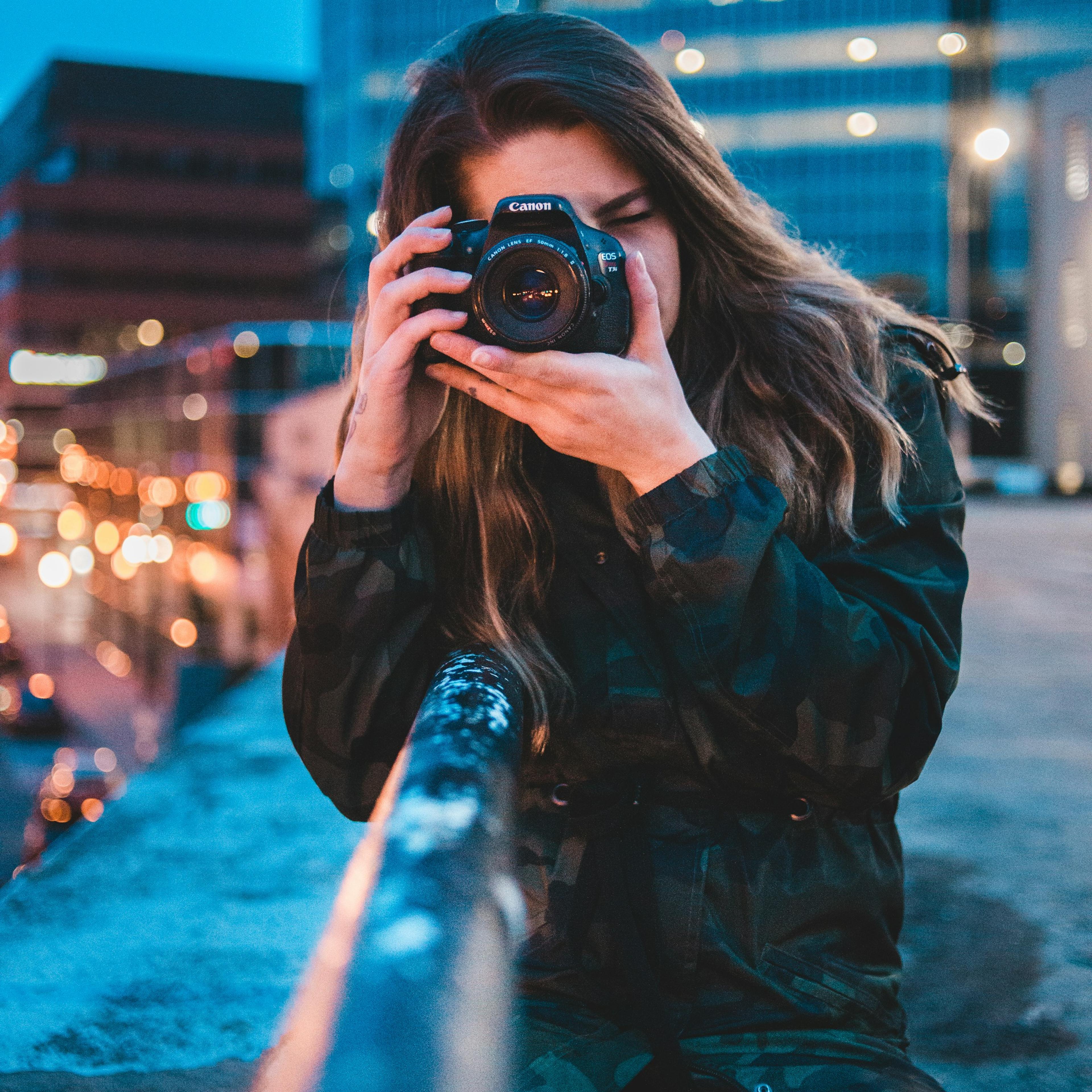 Fotografin mit Kamera in der Stadt am Abend