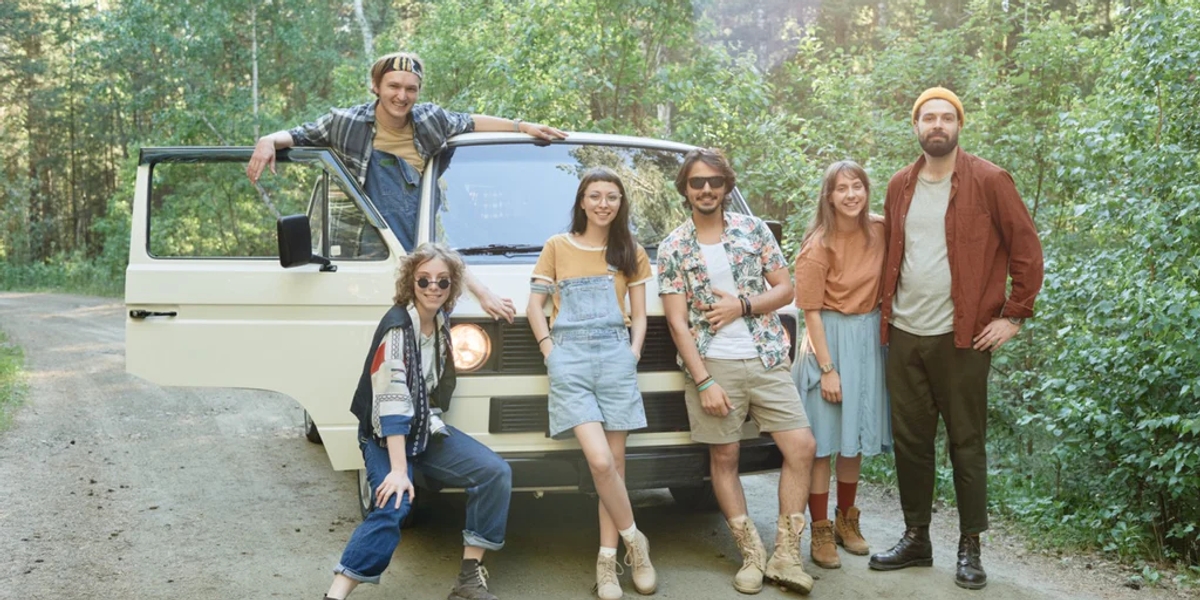 A group of friends standing in front of a minivan