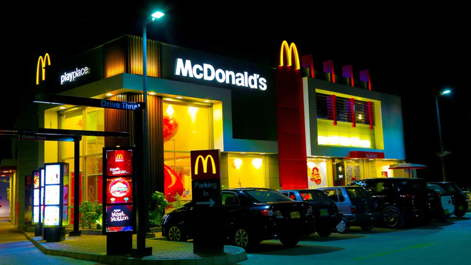 A photo of a McDonald's store lit up at night taken from the outside