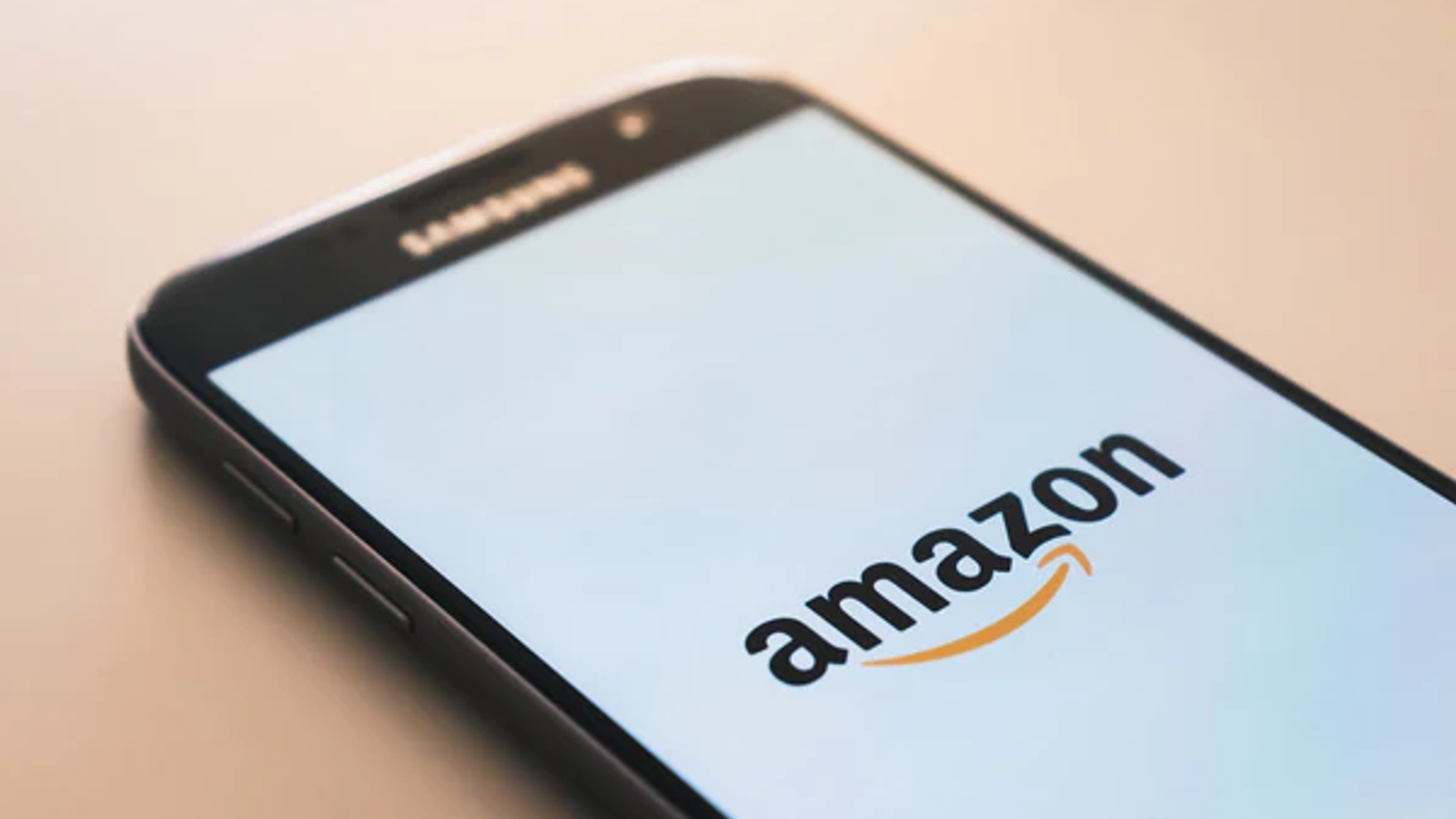 A Samsung smart phone with the Amazon logo on the screen