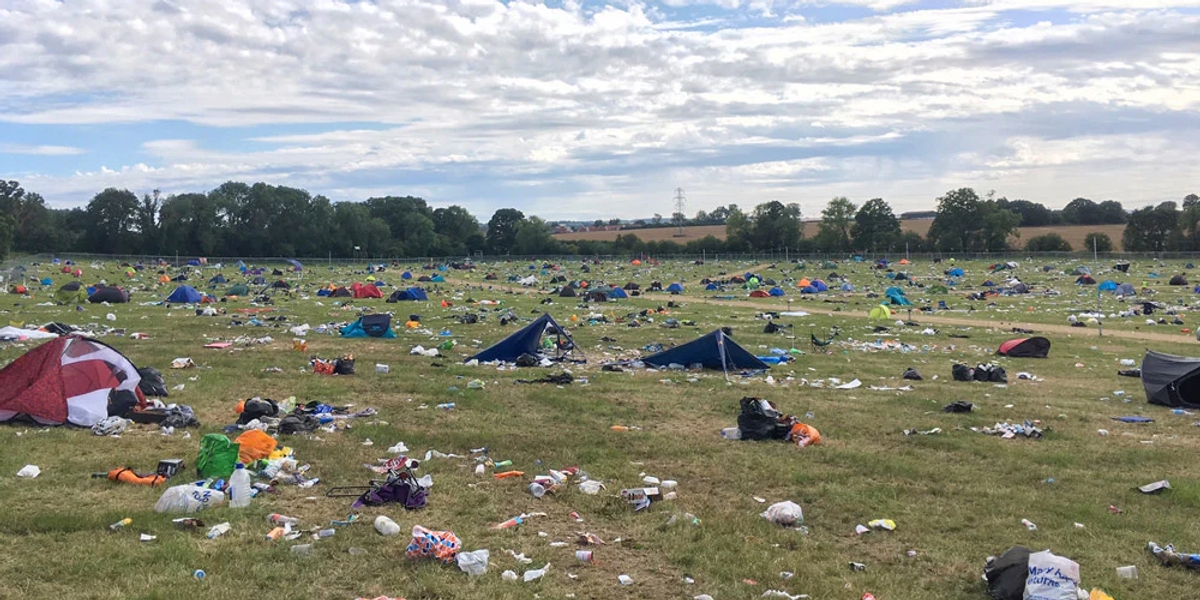 A field at the end of a festival, covered in plastic waste and discarded tents