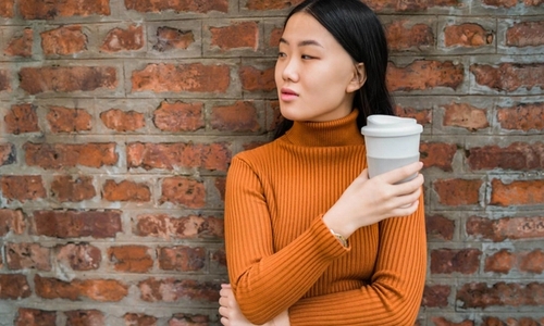 Girl holding a reusable coffee cup
