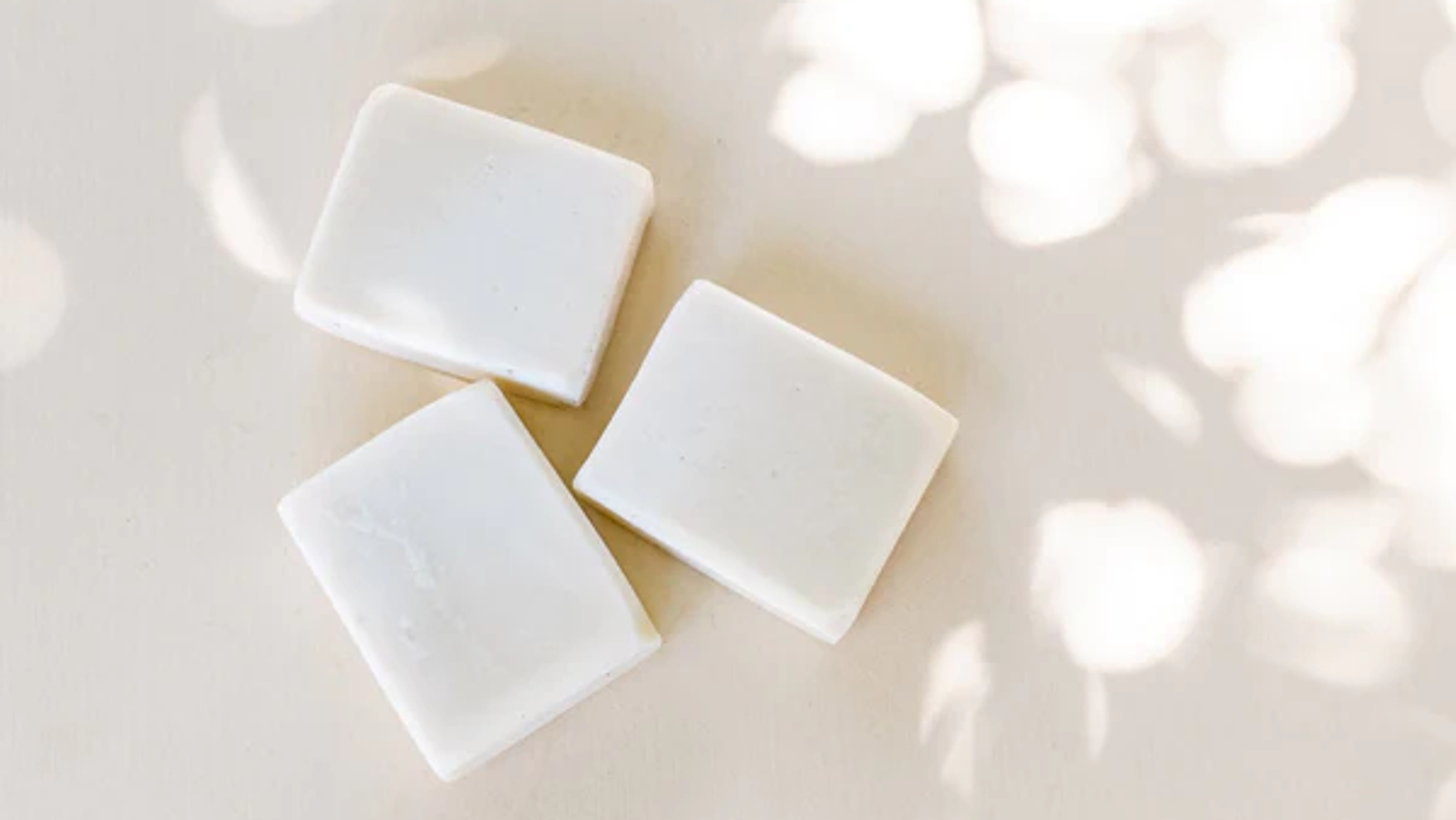Three white bars of soap on a table