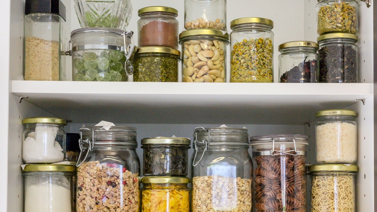 Zero waste cupboard pantry shelves with food in jars