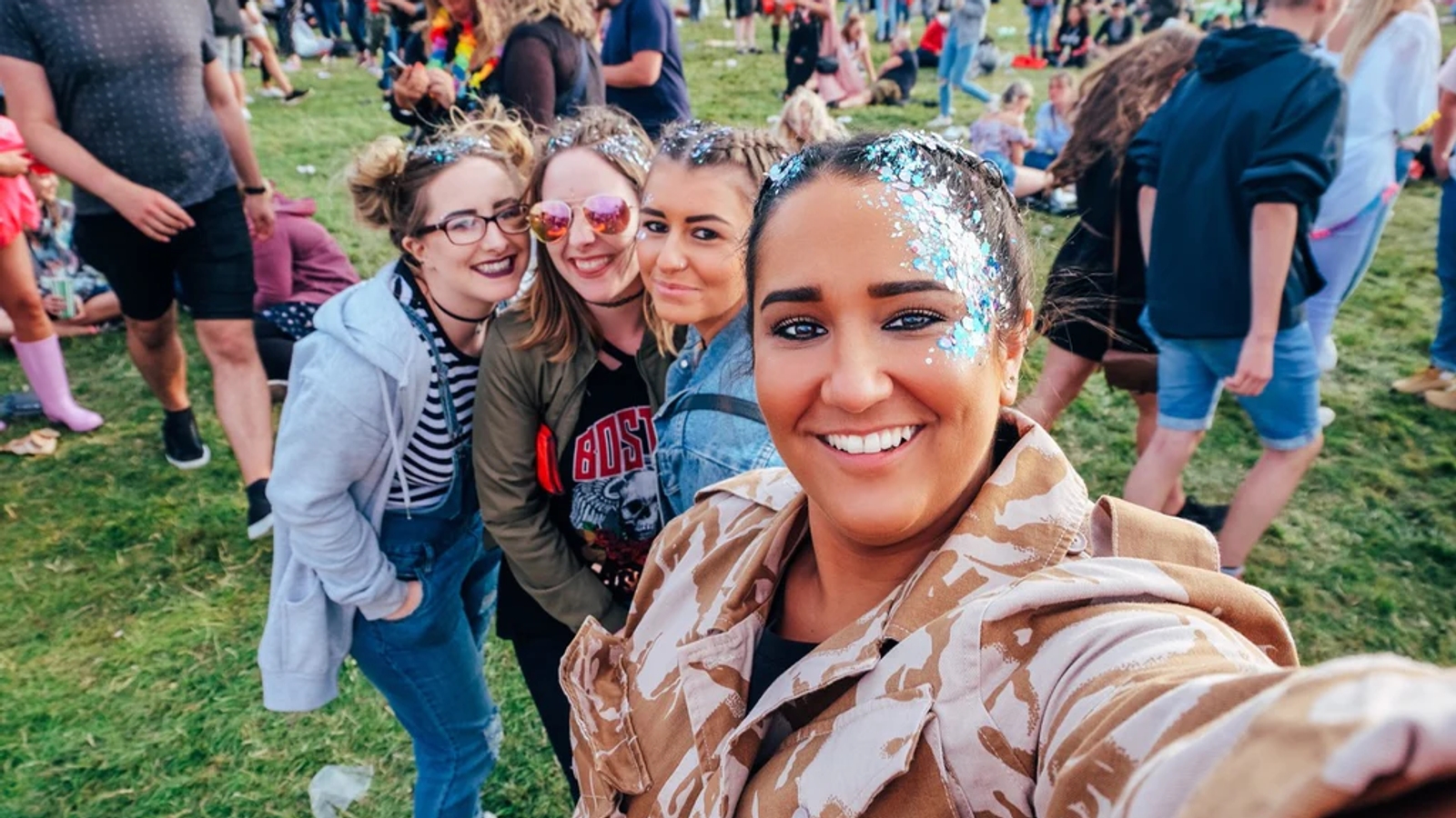 A group of friends at a festival with glitter on their faces