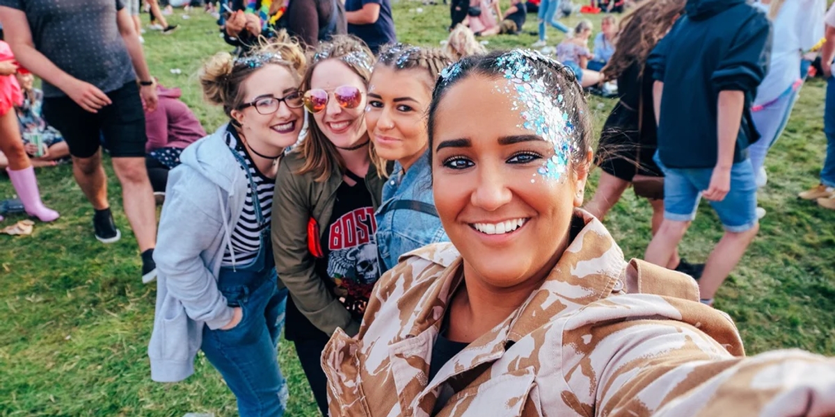 A group of friends at a festival with glitter on their faces