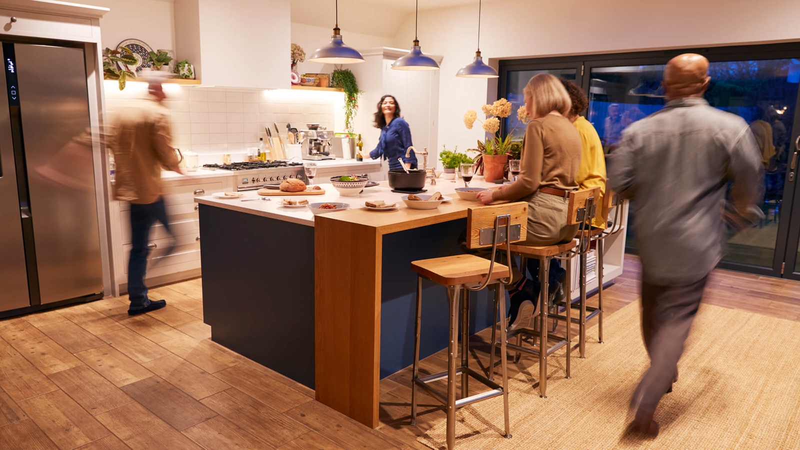 A dinner party in a kitchen with wooden countertops