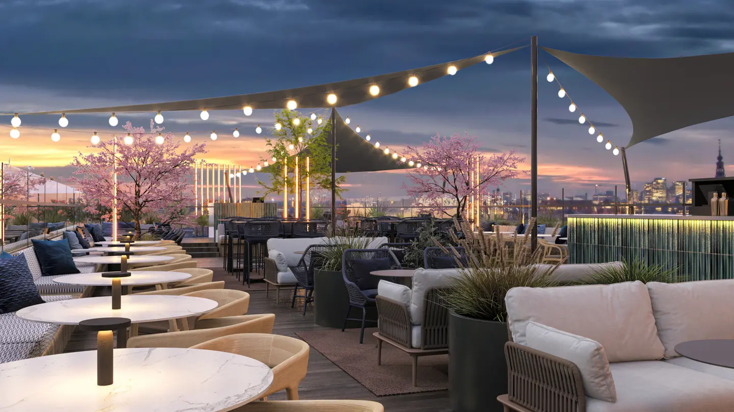 Het rooftop-terras van DoubleTree by Hilton Amsterdam Centraal bij zonsondergang, met sfeerverlichting, kersenbloesem en lounge-meubilair