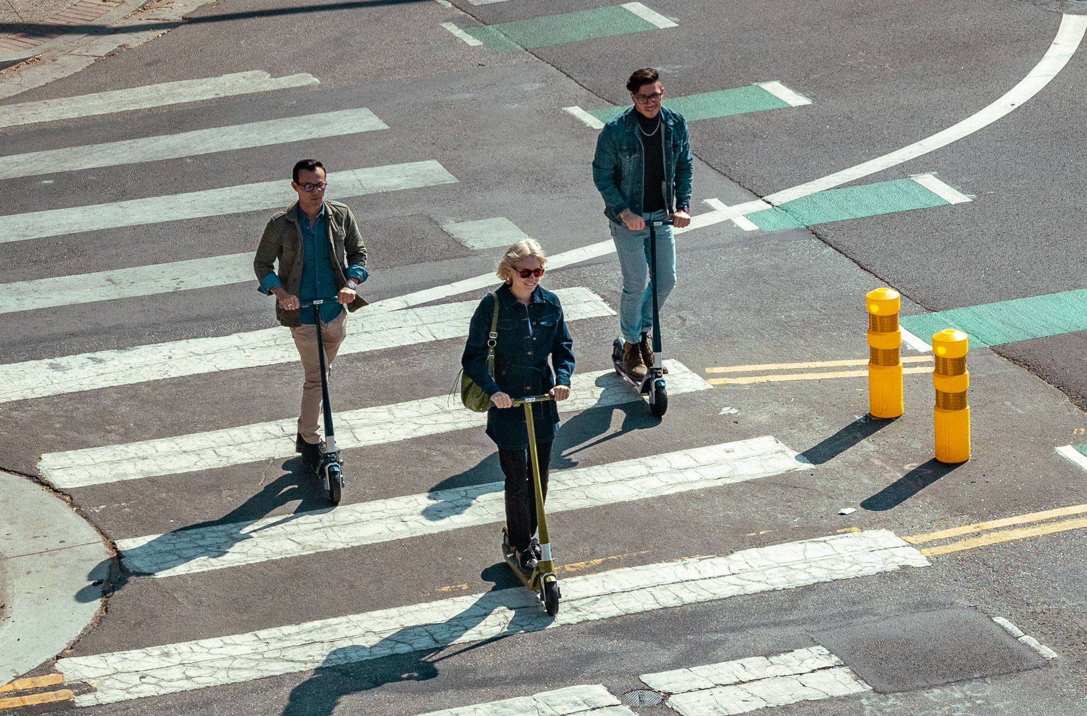 People cross the pedestrian crossing with electric scooters