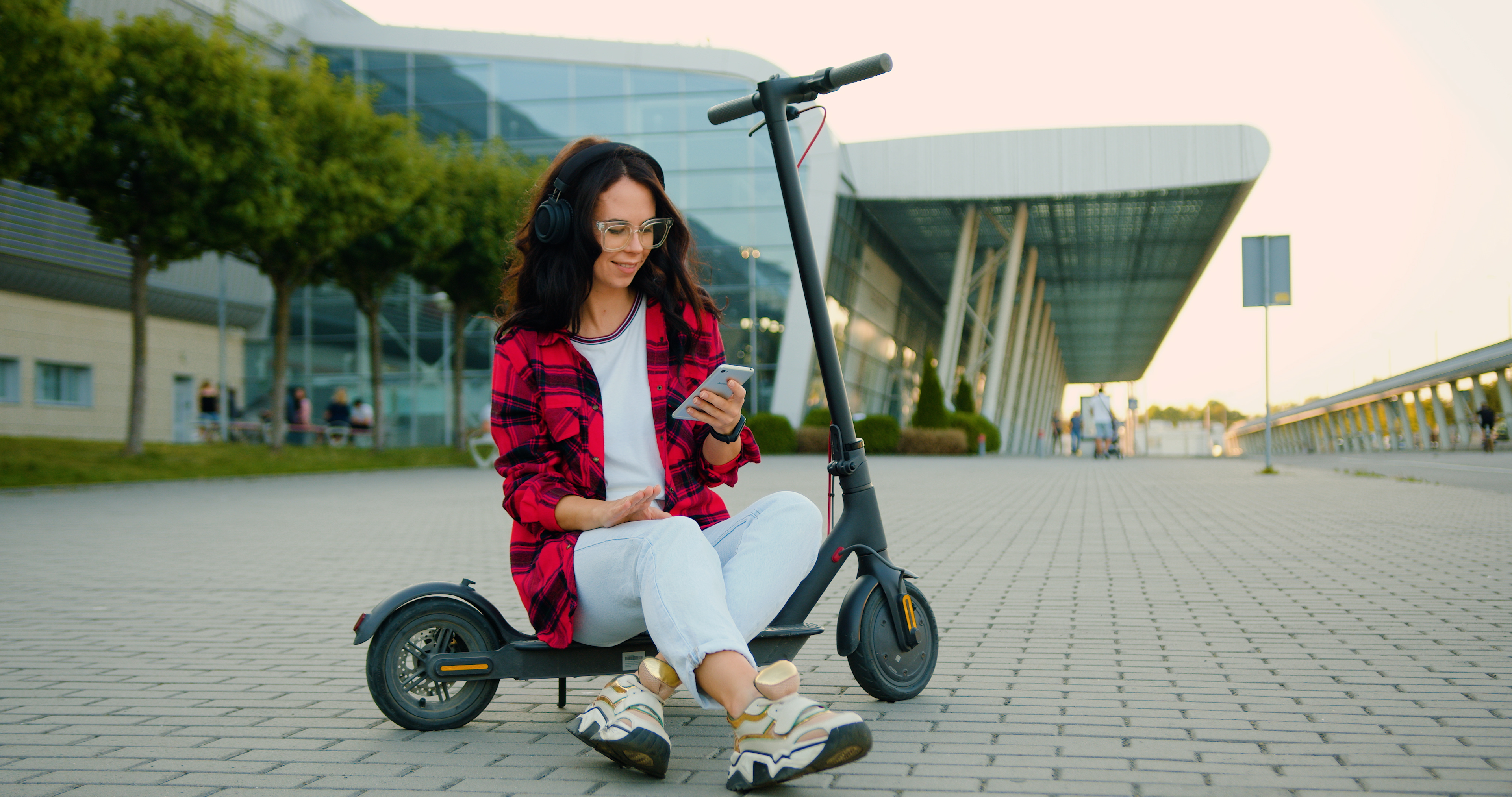 woman with the phone on electric scooter