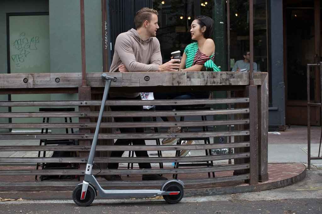 couple drinking coffee with unagi electric scooter