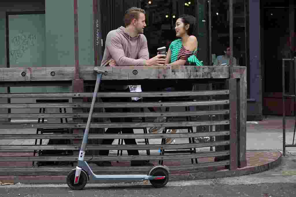 couple drinking coffee with electric scooter