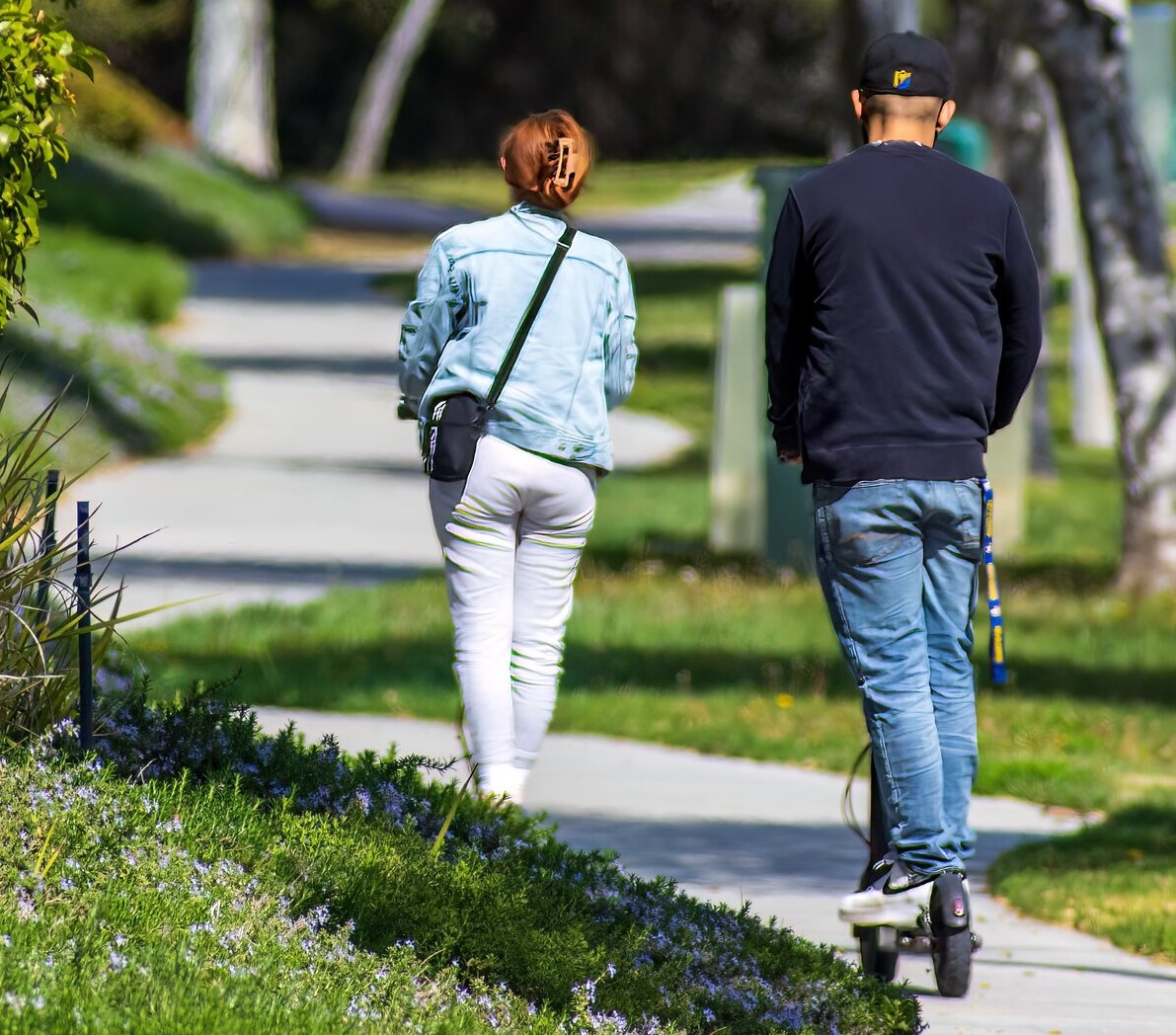 Rear view of young man and woman riding in the park