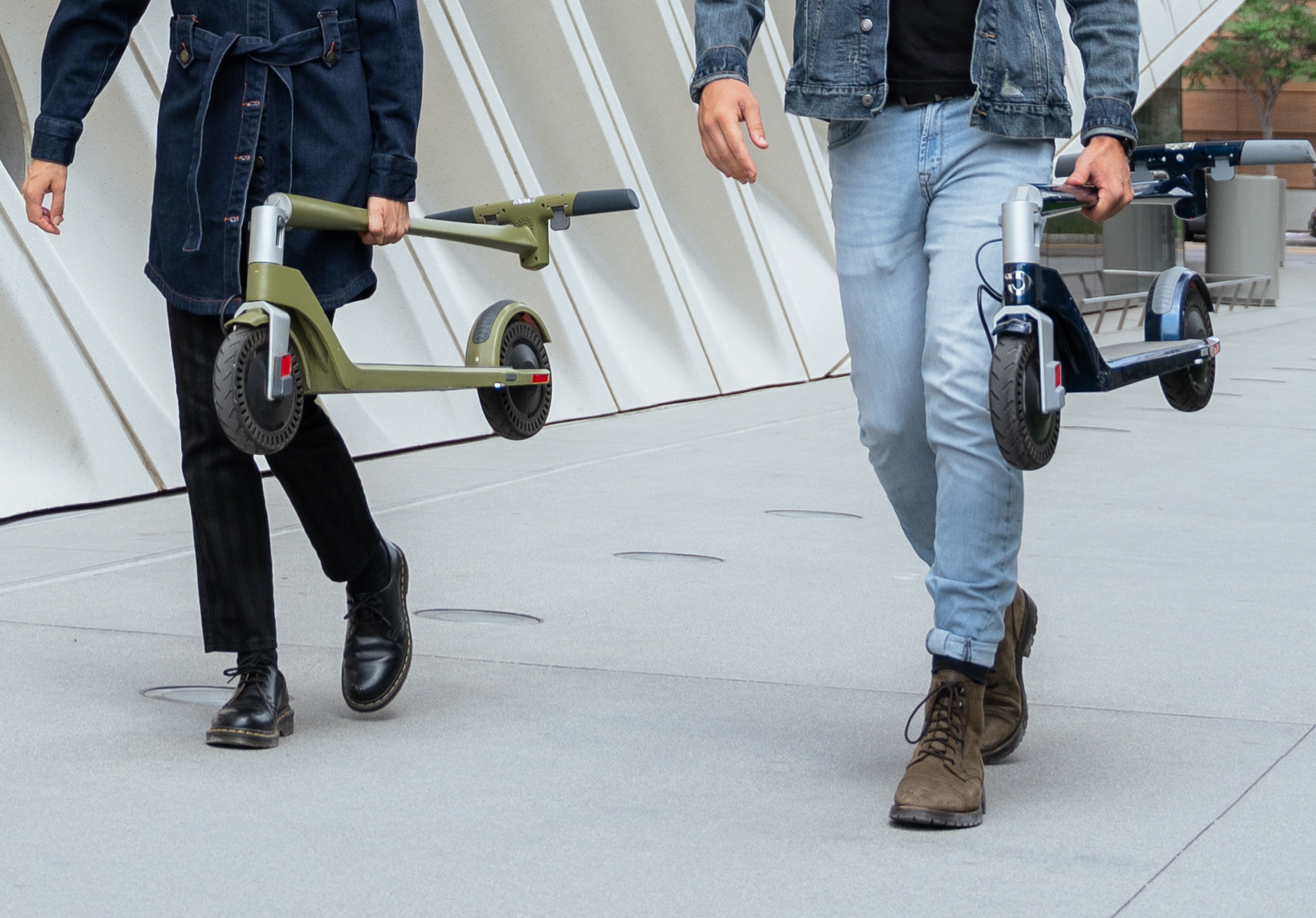 people holds electric scooters