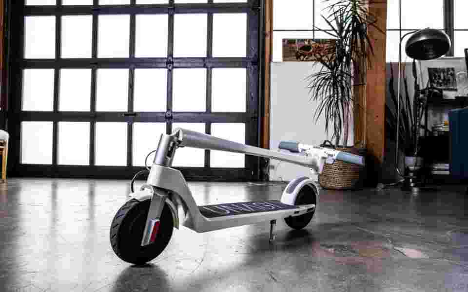 Folded e-scooter parked in industrial loft space with concrete floor