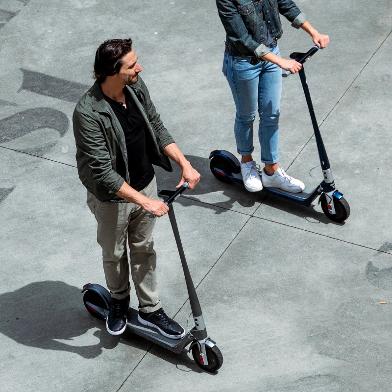 two people riding scooters