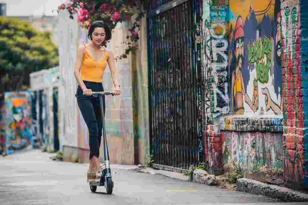 Asian young woman riding Unagi electric scooter