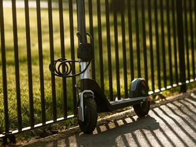 E scooter locked to railings with cable lock