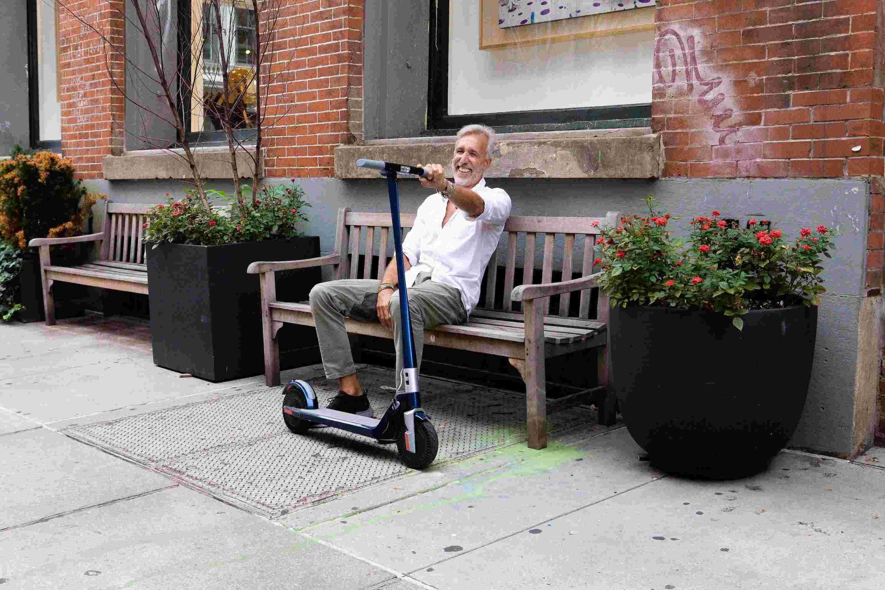 Middle Aged Man Sitting With Electric Scooter