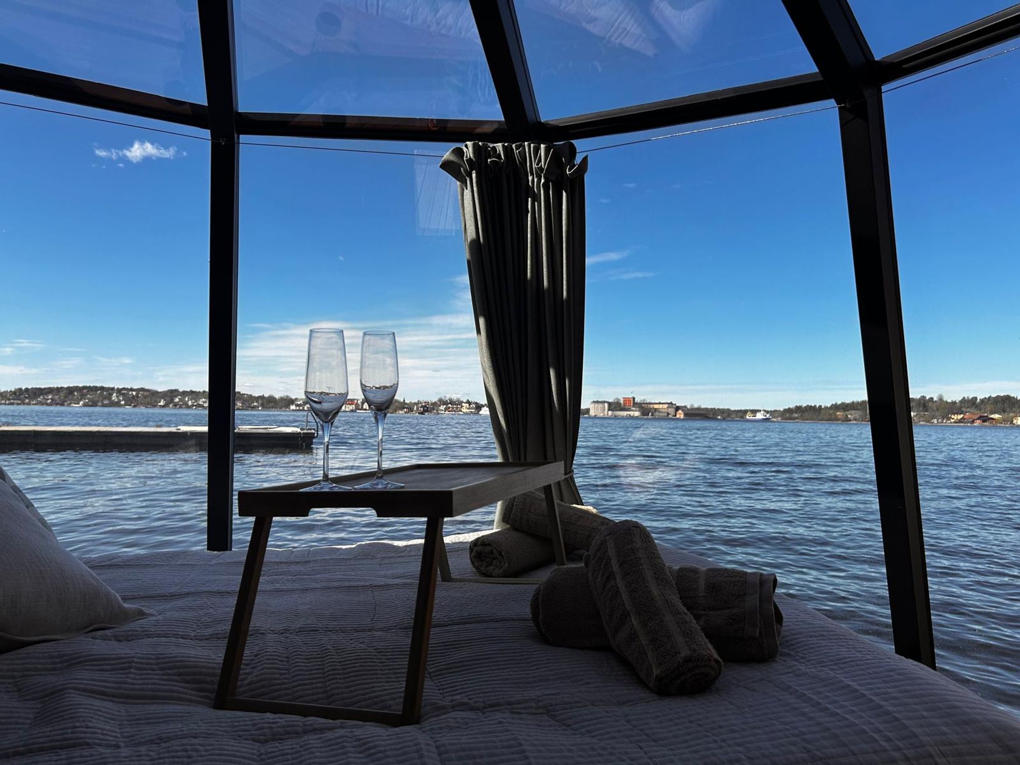 Flytande igloohydda med panoramafönster förtöjd vid bryggan på Tynningö i Stockholms skärgård.