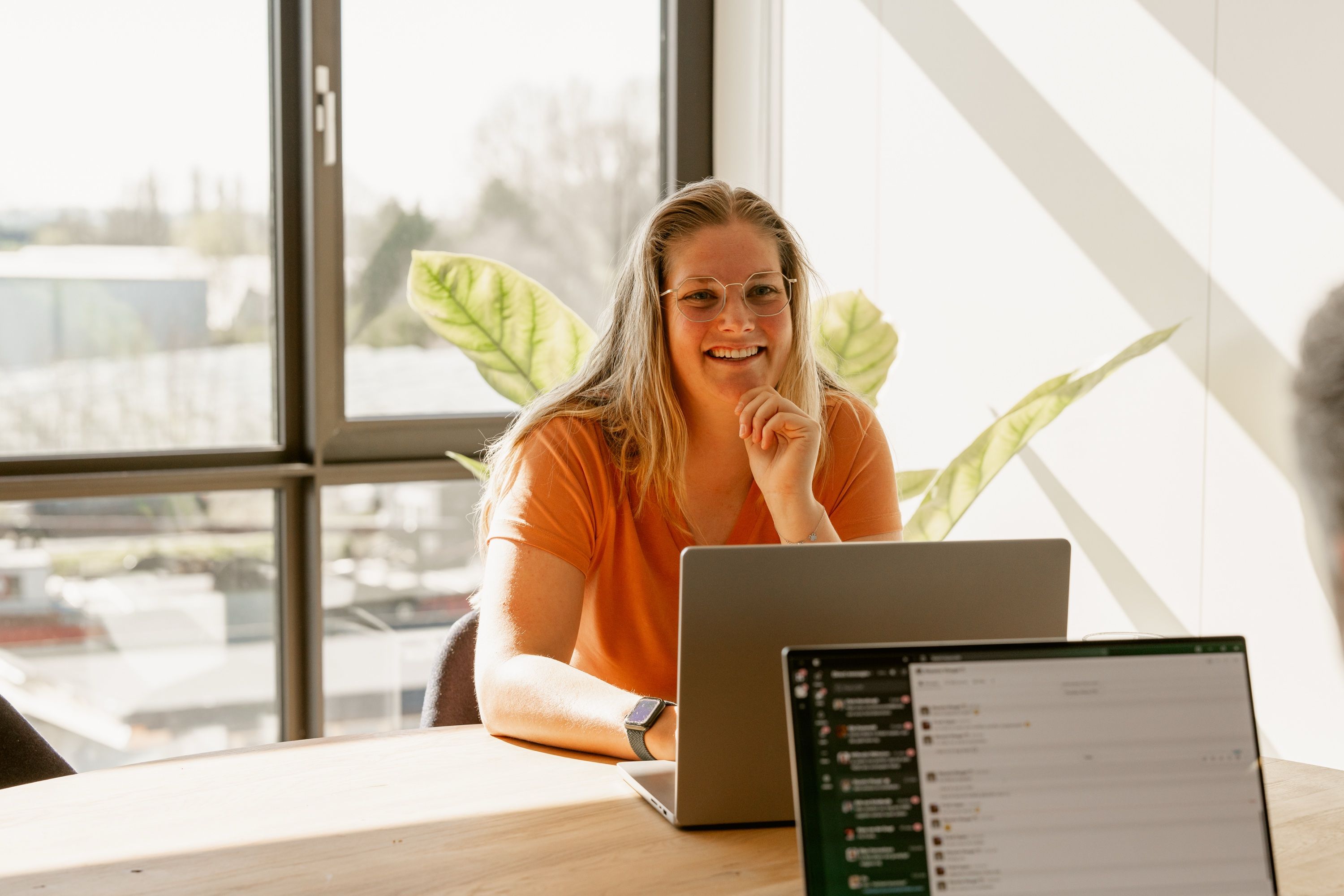 Shyanta Vleugel at a table with a laptop by the window.