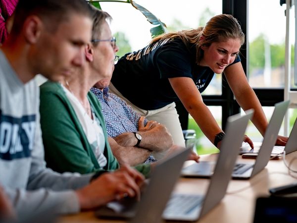 Supporting participants working on laptops during a learning session.