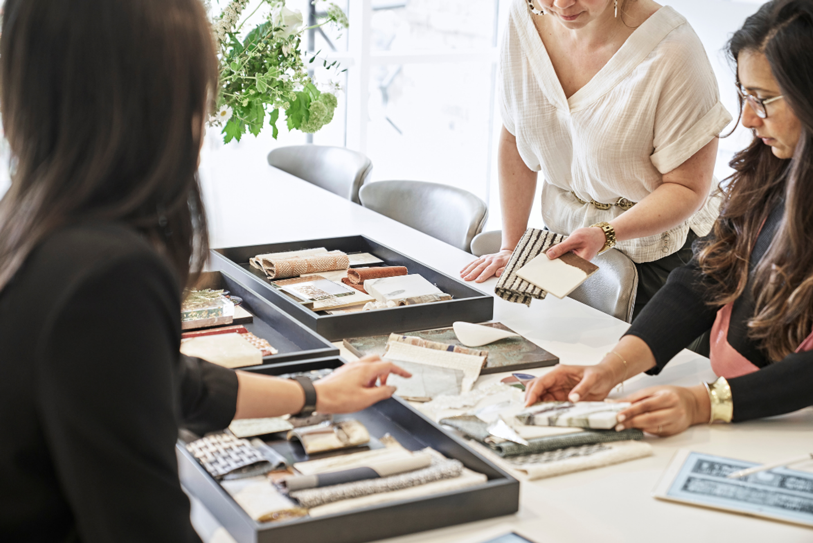Elicyon designers reviewing fabric and surface samples during a concept meeting in the London studio.