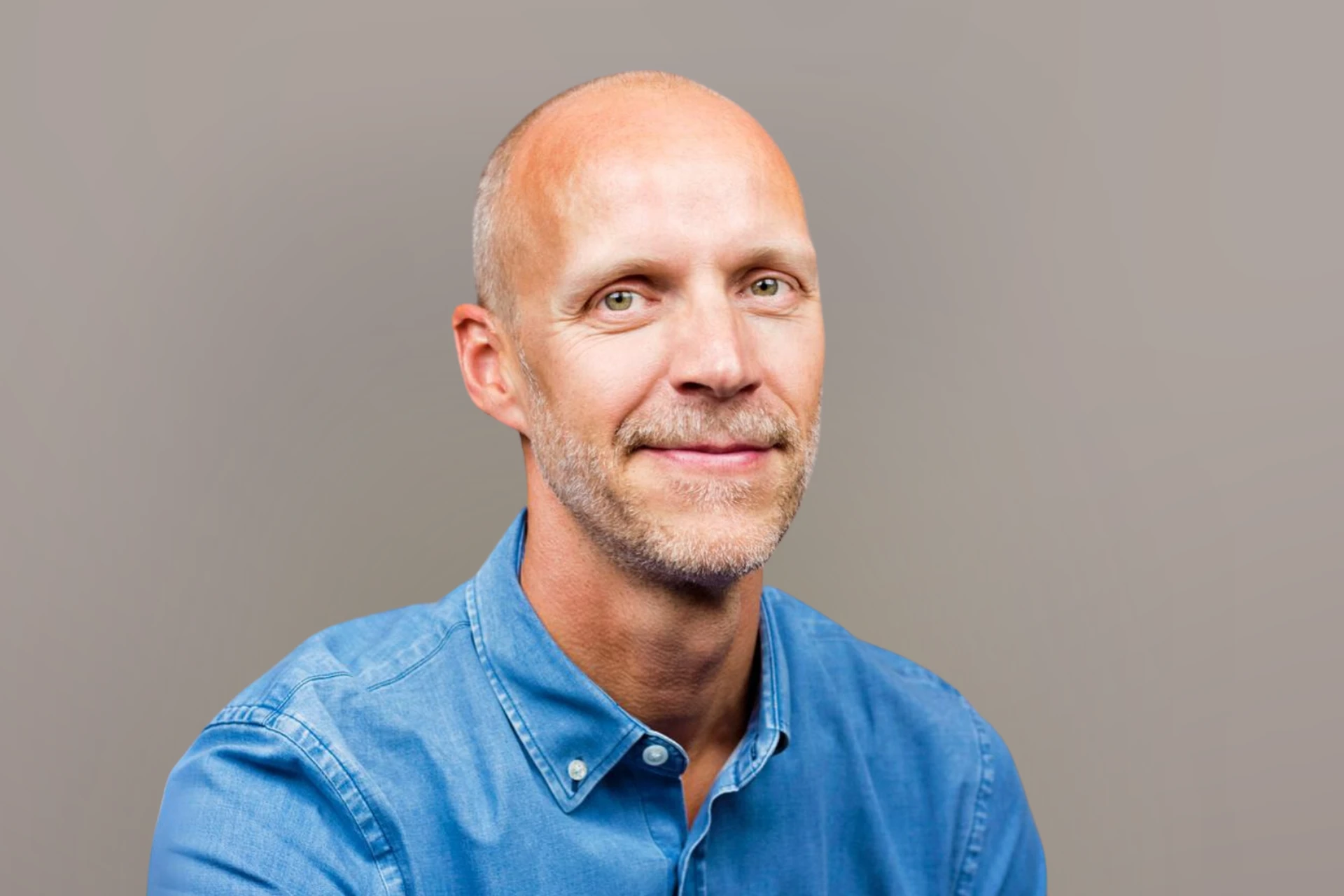 Porträttfotografi av författaren och föreläsaren Niklas Delmar framför grå bakgrund.