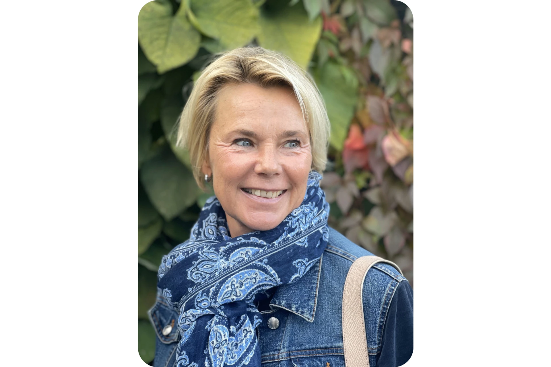 Martina Brandt ler klädd i blått, bakom henne syns växter.