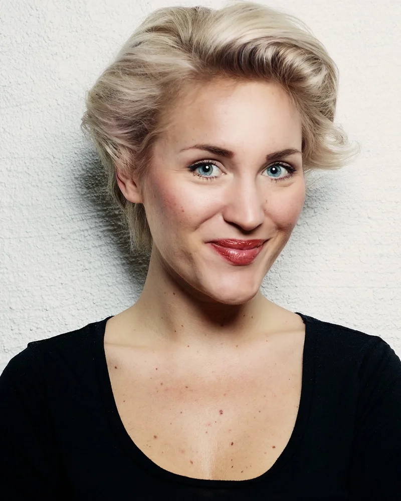 Anja Melander i kort, blont hår och en svart topp ler mot kameran.