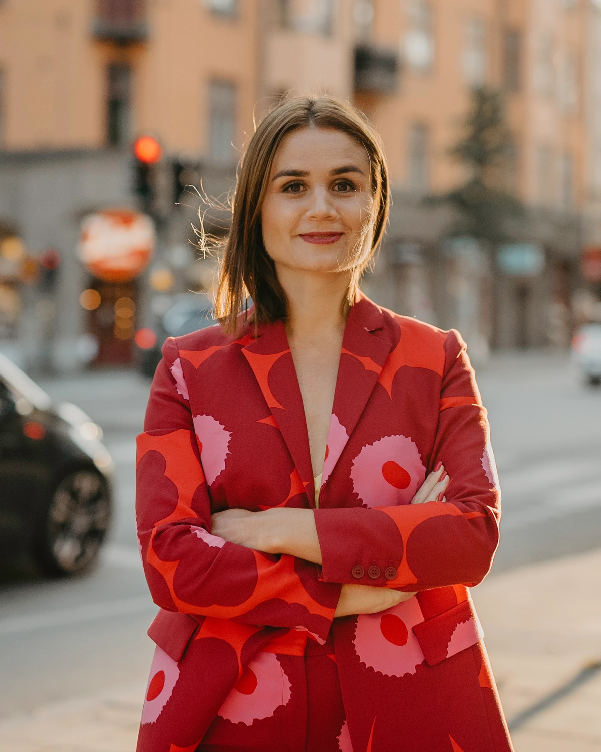 Bilden visar AI-experten och techprofilen Paulina Modlitba som står leende i röd kavaj med trafik i bakgrunden.