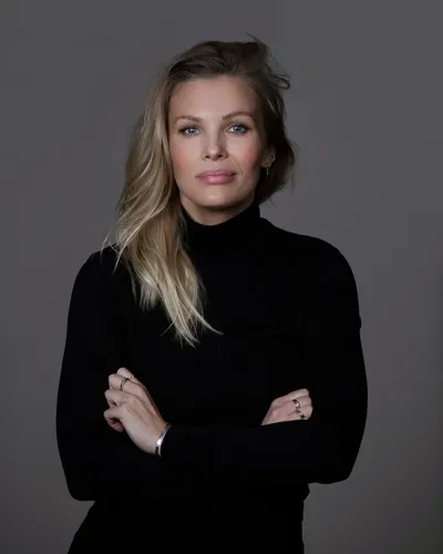 Föreläsaren och författaren Fi Lindfors i svart polotröja mot grå bakgrund