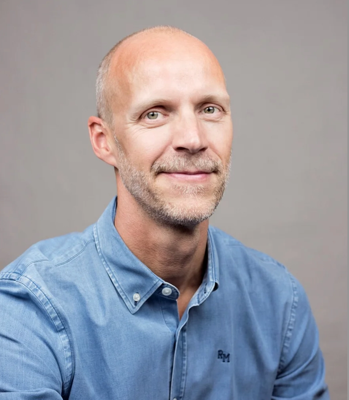 Föreläsaren Niklas Delmar i jeansskjorta mot grå bakgrund