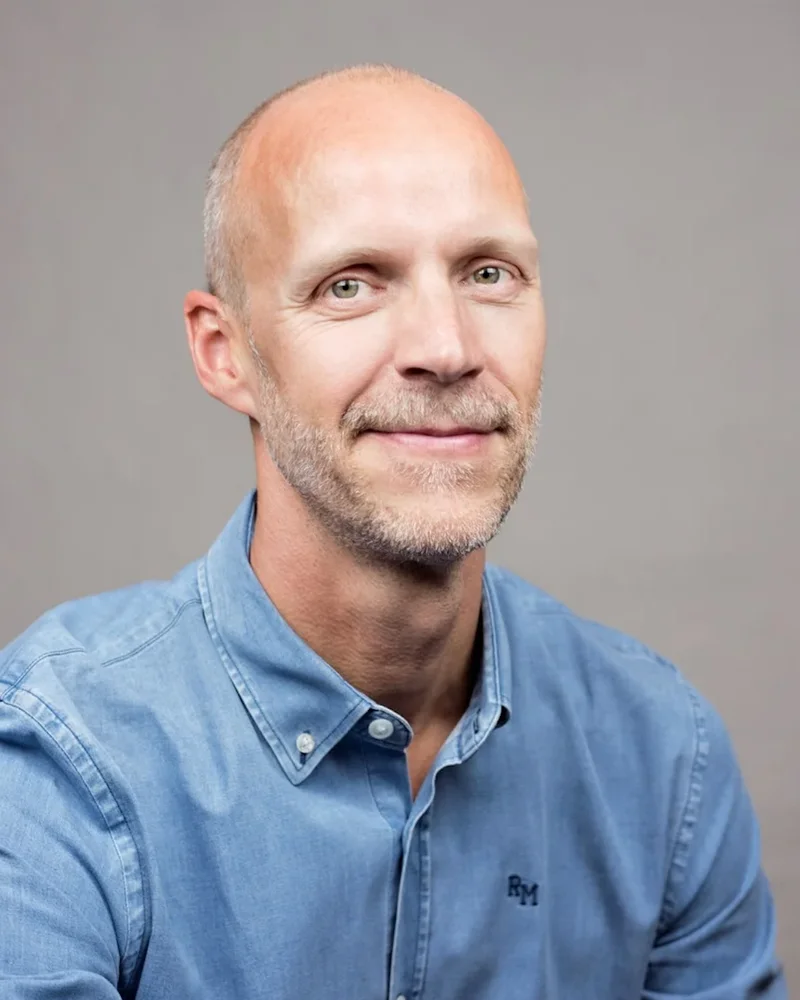 Föreläsaren Niklas Delmar i jeansskjorta mot grå bakgrund