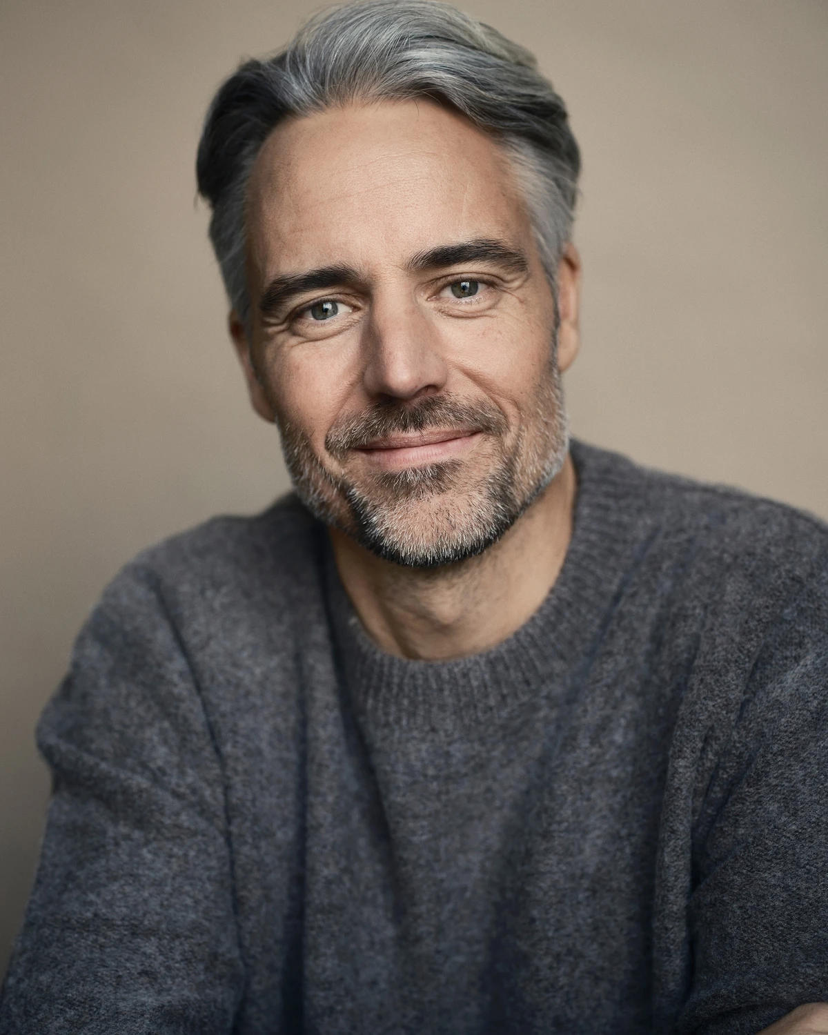 Bilden visar epidemiologen och läkaren Anders Wallensten i en grå stickad tröja och med ett leende på läpparna.