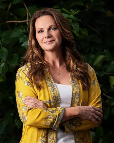 Veronica Linarfve i gulmönstrad kimono med grön natur och löv i bakgrunden.