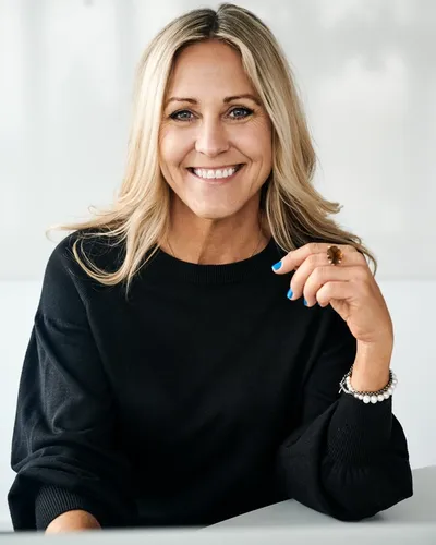 Ekonomiexperten och föreläsaren Christina Sahlberg leendes i svart blus mot ljus bakgrund