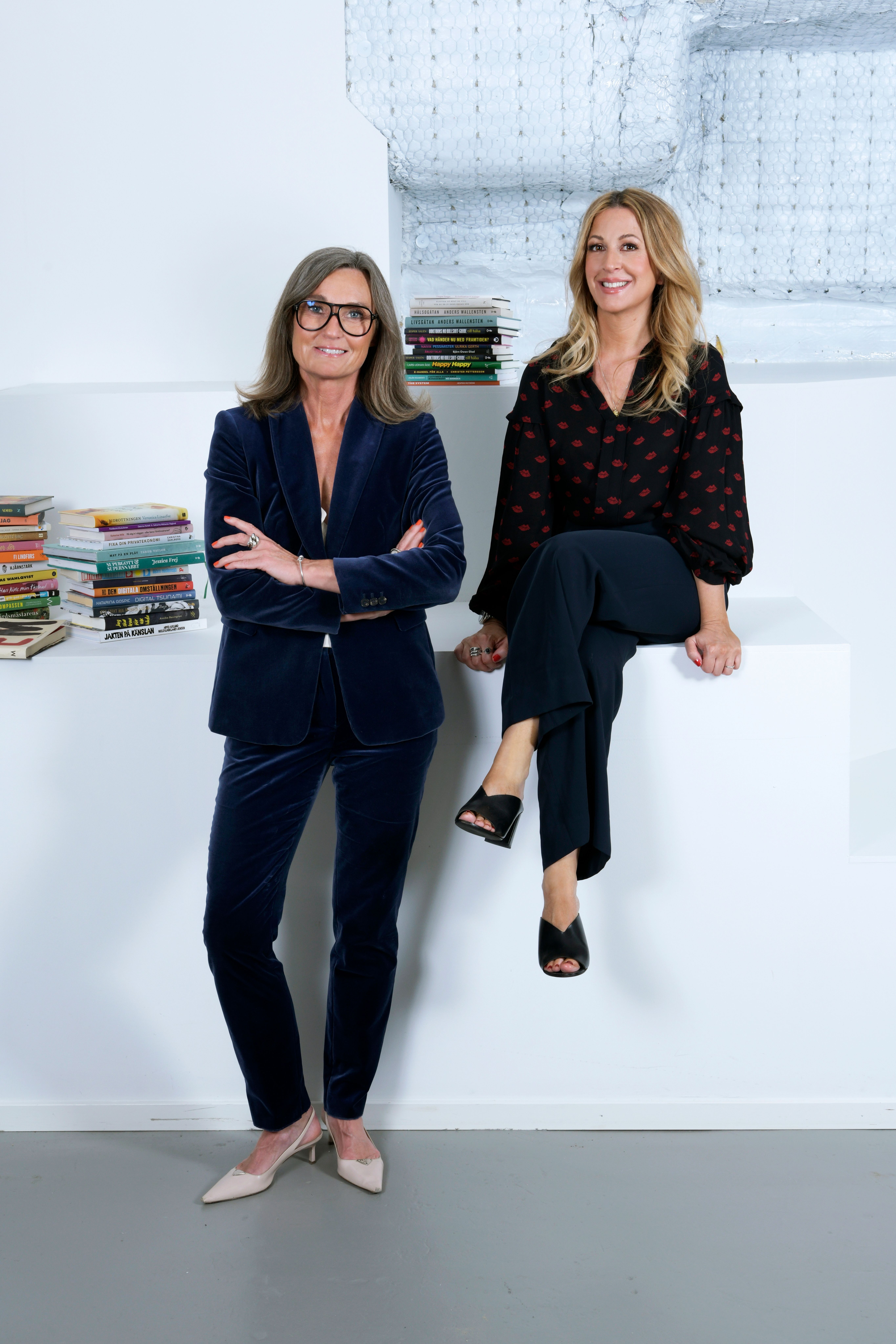 BYWRTRS Anna-Lena Hernvall och Alexandra Appelqvist står leende bredvid böcker
