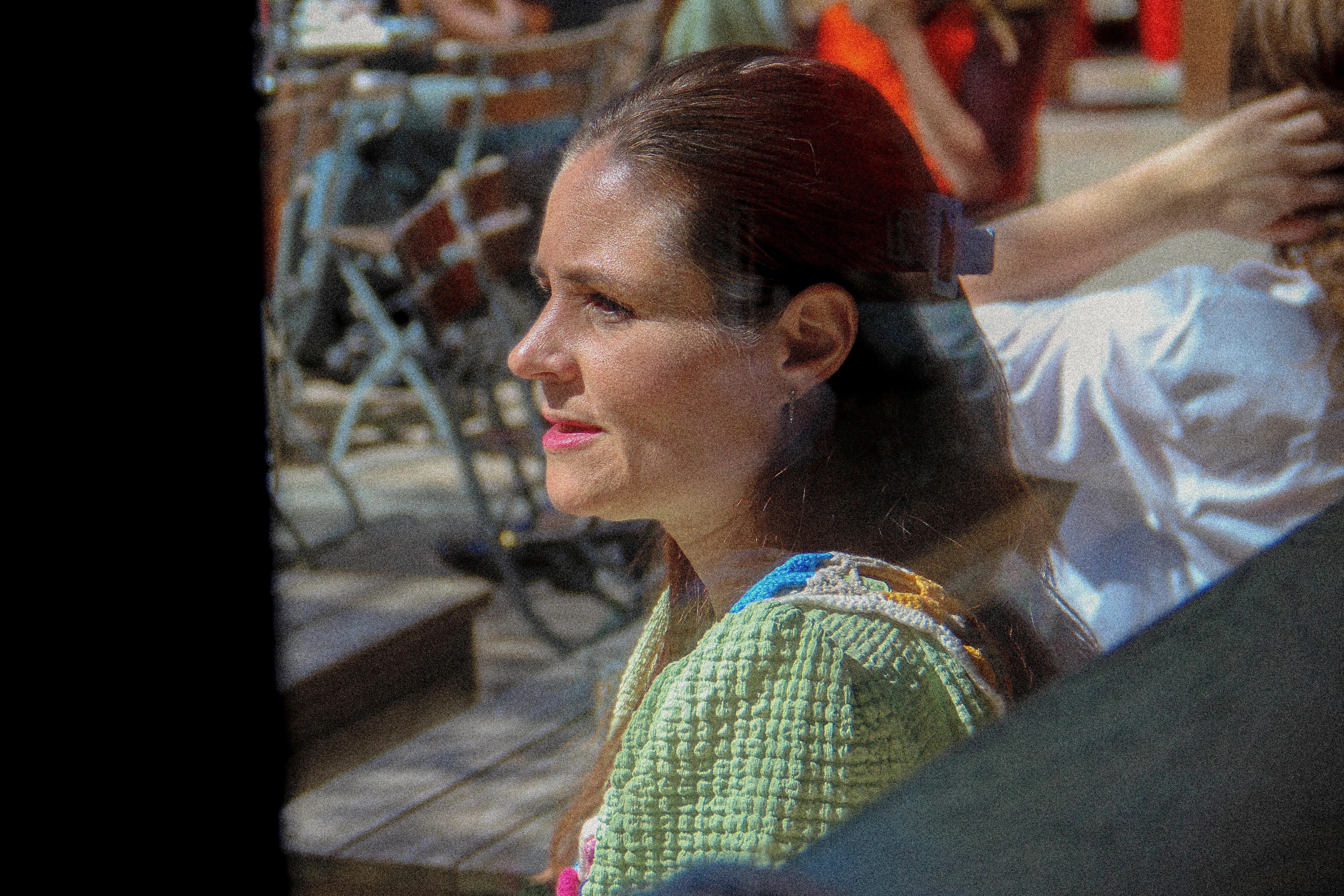 Paulina Modlitba syns genom ett fönster, där hon sitter med solen i ansiktet. 