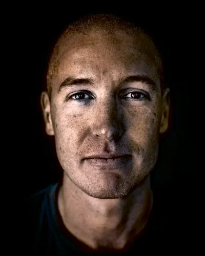 Närbild på AI-vetaren Kye Andersson mot mörk bakgrund