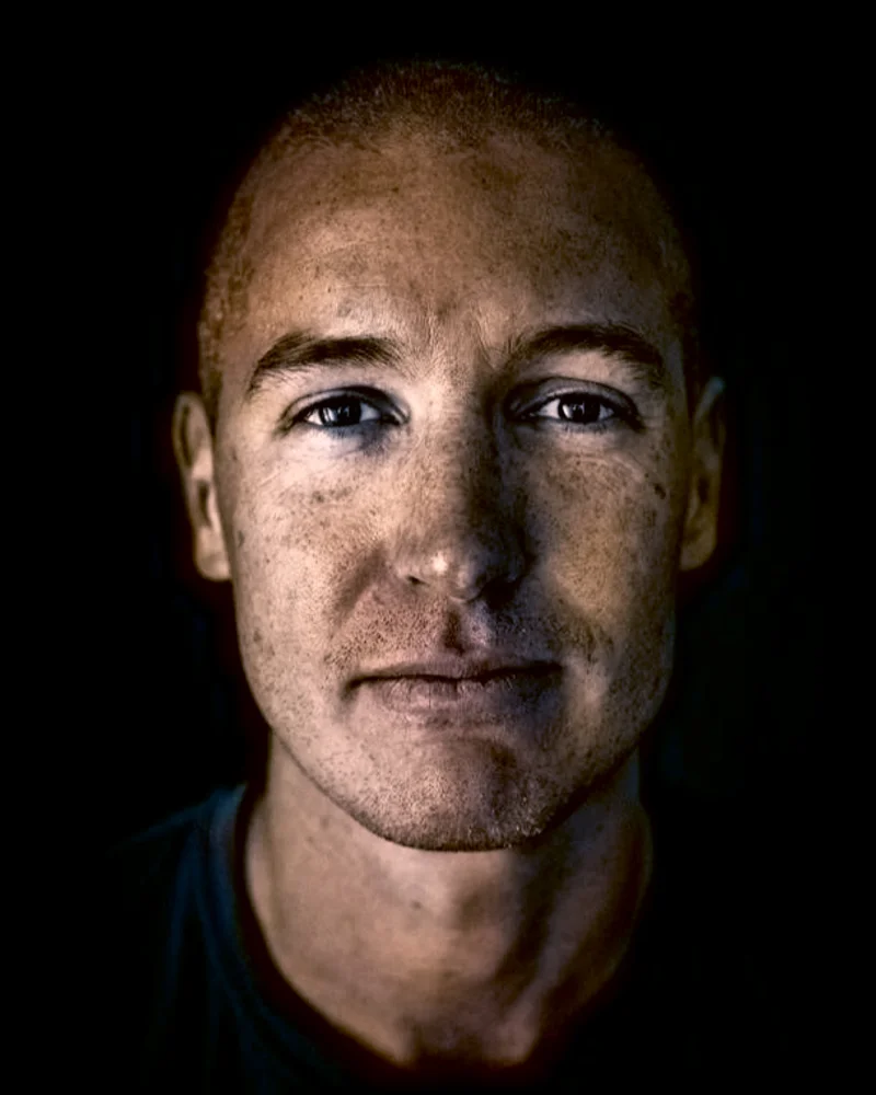 Närbild på AI-vetaren Kye Andersson mot mörk bakgrund