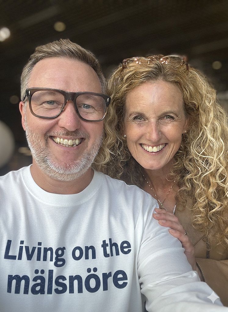 Jens Wedin och Linda Öhling står leende med en tröja Living on the målsnöre