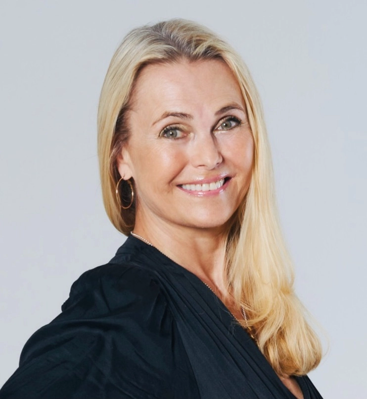 Katarina Mannheimer, föreläsare i svart blus mot grå bakgrund leendes mot kameran