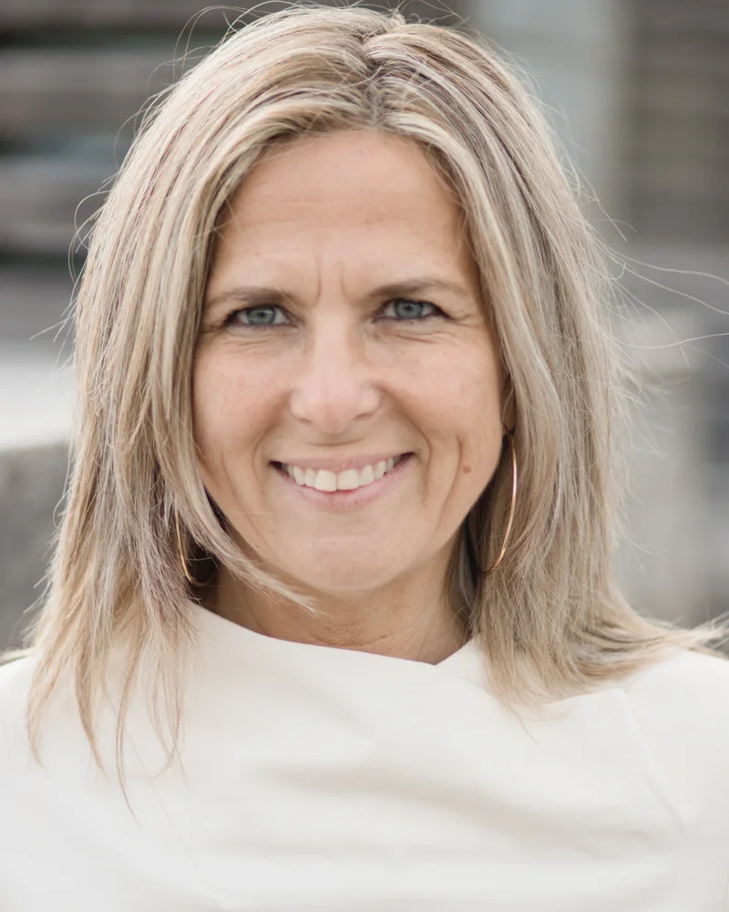 Storytellern och inspiratören Tarja Rosén tittar rakt in i kameran med ett leende, hon är klädd i en vit stickad tröja.