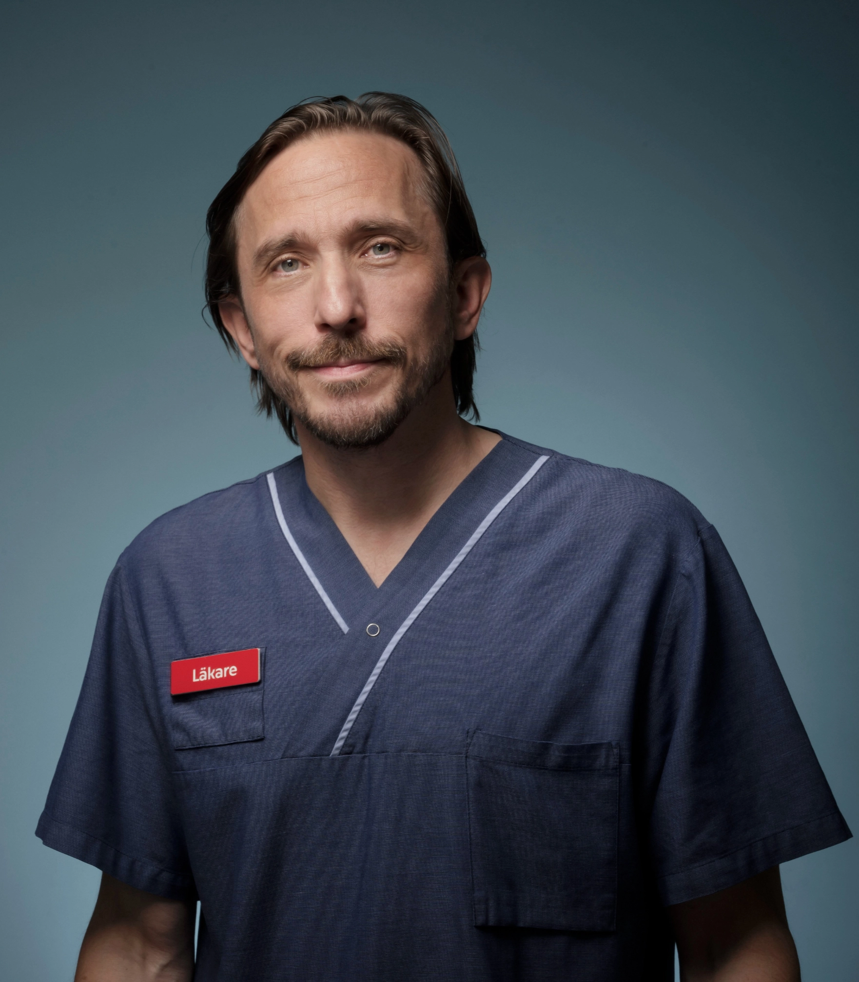 Läkare och författare Jesper Salén i sina doktorskläder och namnskylt